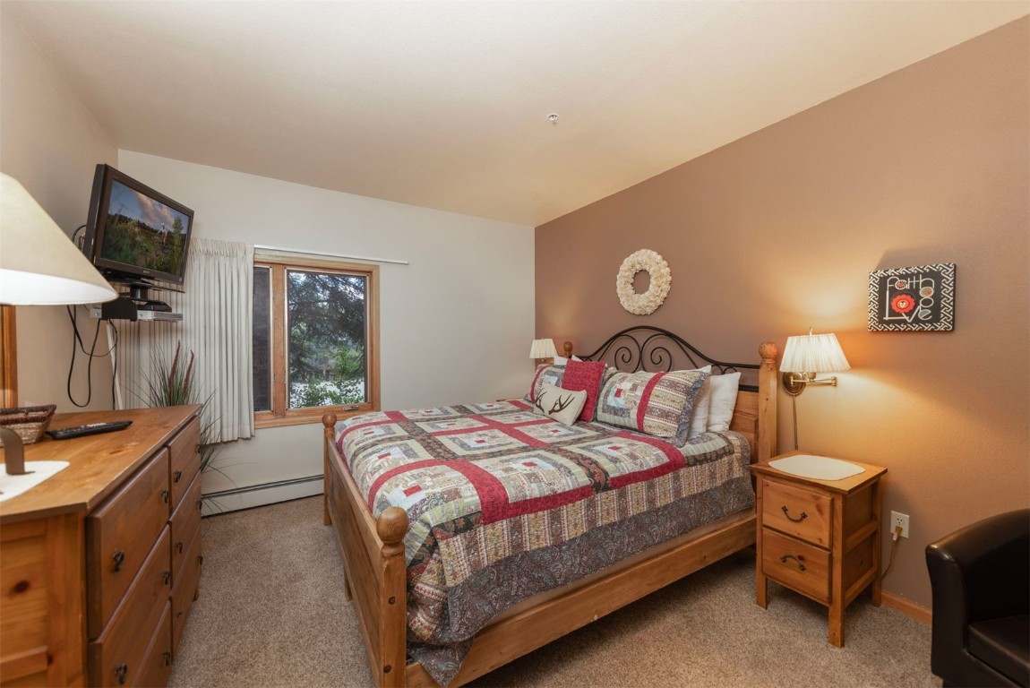 600 4 O Clock Road, Unit A11 Breckenridge, CO 80424 - Photo 13 of 22 a bedroom with a bed and a flat screen tv