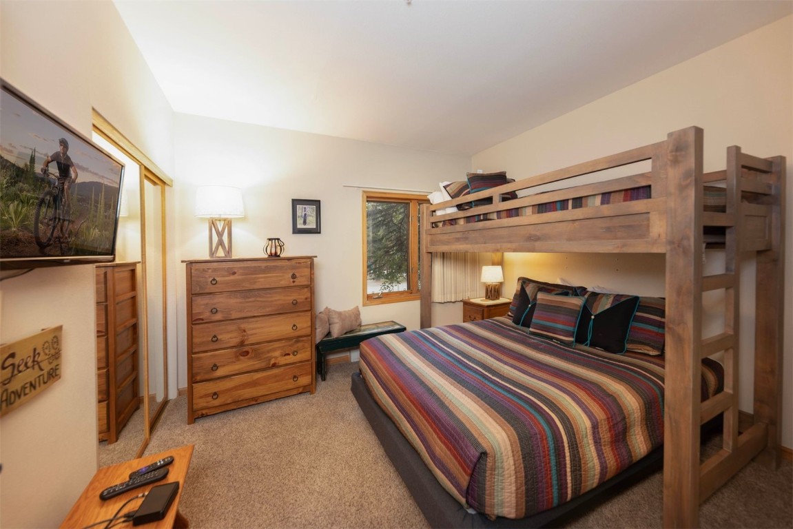 600 4 O Clock Road, Unit A11 Breckenridge, CO 80424 - Photo 15 of 22 a bedroom with a bed and a flat tv screen