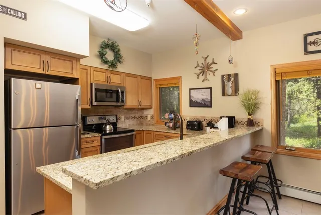 a kitchen with stainless steel appliances granite countertop a refrigerator and a stove top oven