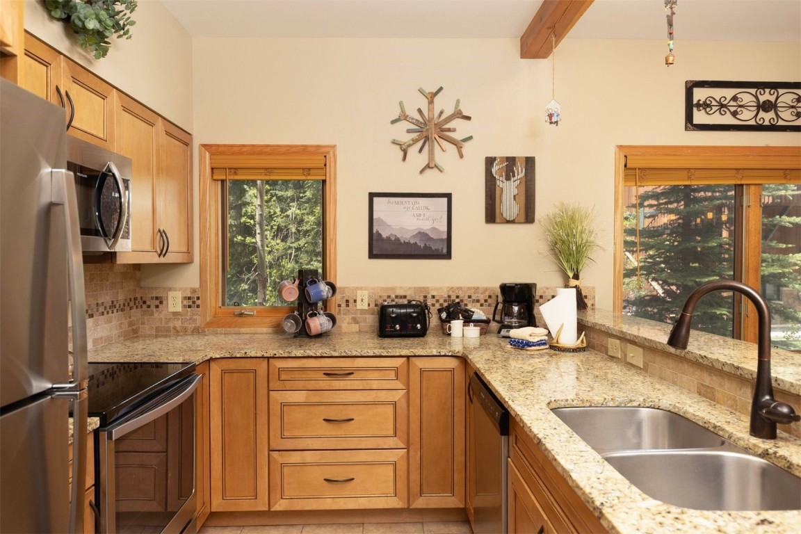 600 4 O Clock Road, Unit A11 Breckenridge, CO 80424 - Photo 10 of 22 a kitchen with granite countertop a sink stove and cabinets