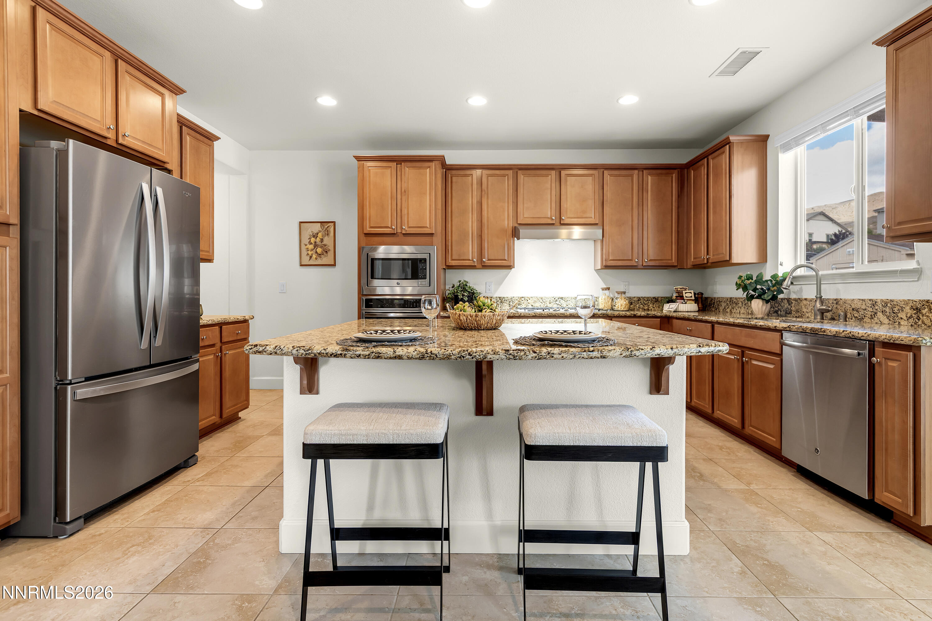 10150 Barrel Racer Drive Reno, NV 89521 - Photo 19 of 64 a kitchen with kitchen island granite countertop wooden cabinets stainless steel appliances and a window