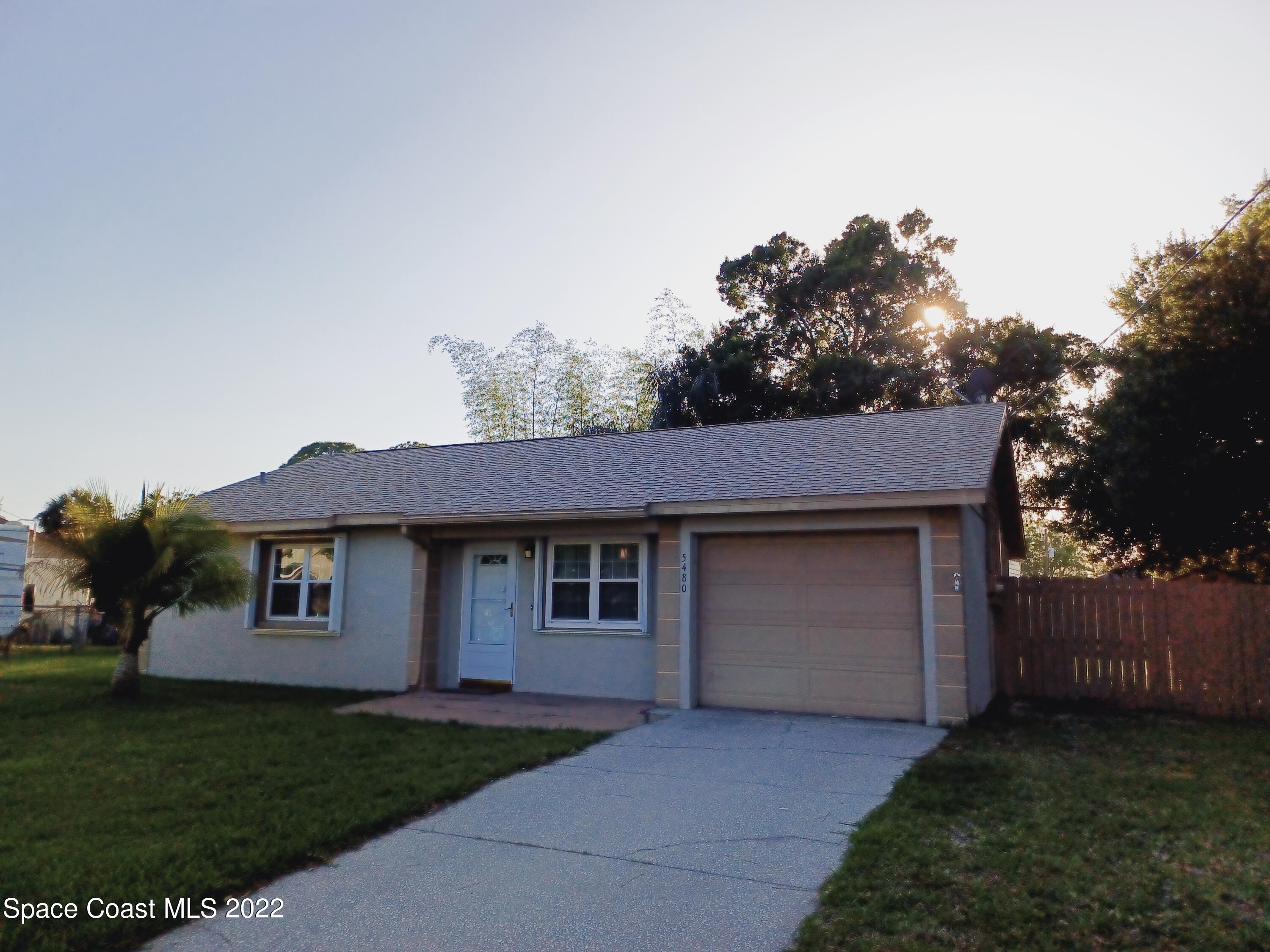 5480 Flint Road Cocoa, FL 32927 - Photo 1 of 20 a front view of a house with a garden and trees