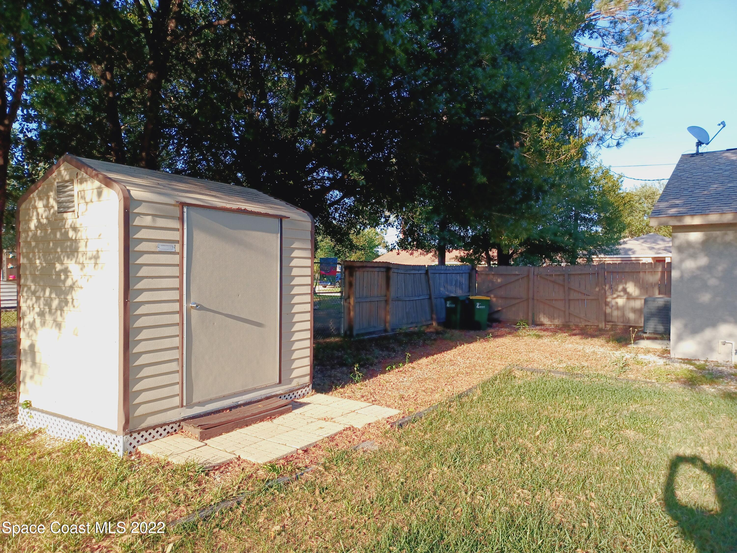 5480 Flint Road Cocoa, FL 32927 - Photo 18 of 20 a backyard of a house with garage and door