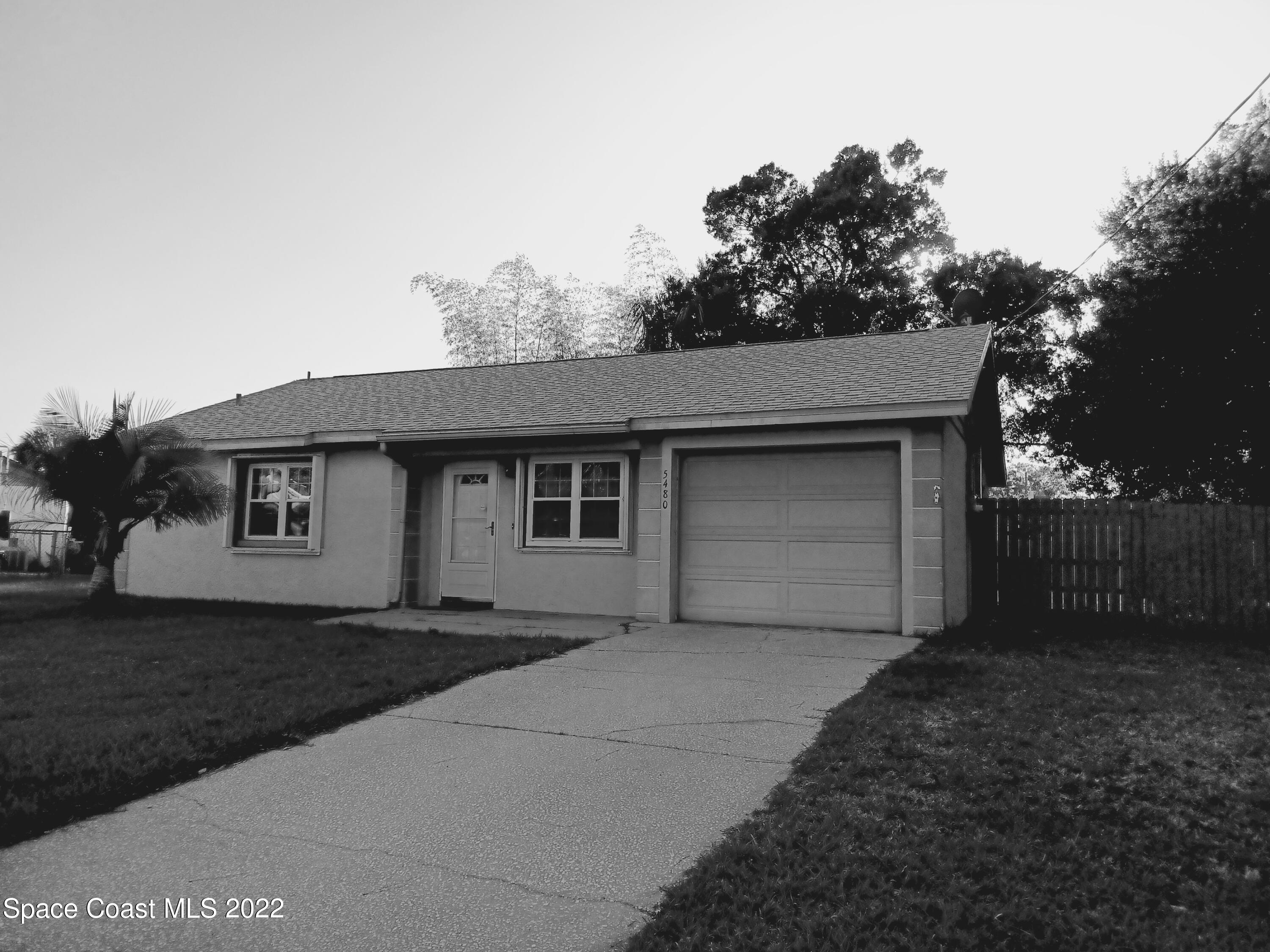 5480 Flint Road Cocoa, FL 32927 - Photo 2 of 20 a front view of a house with a yard and garage
