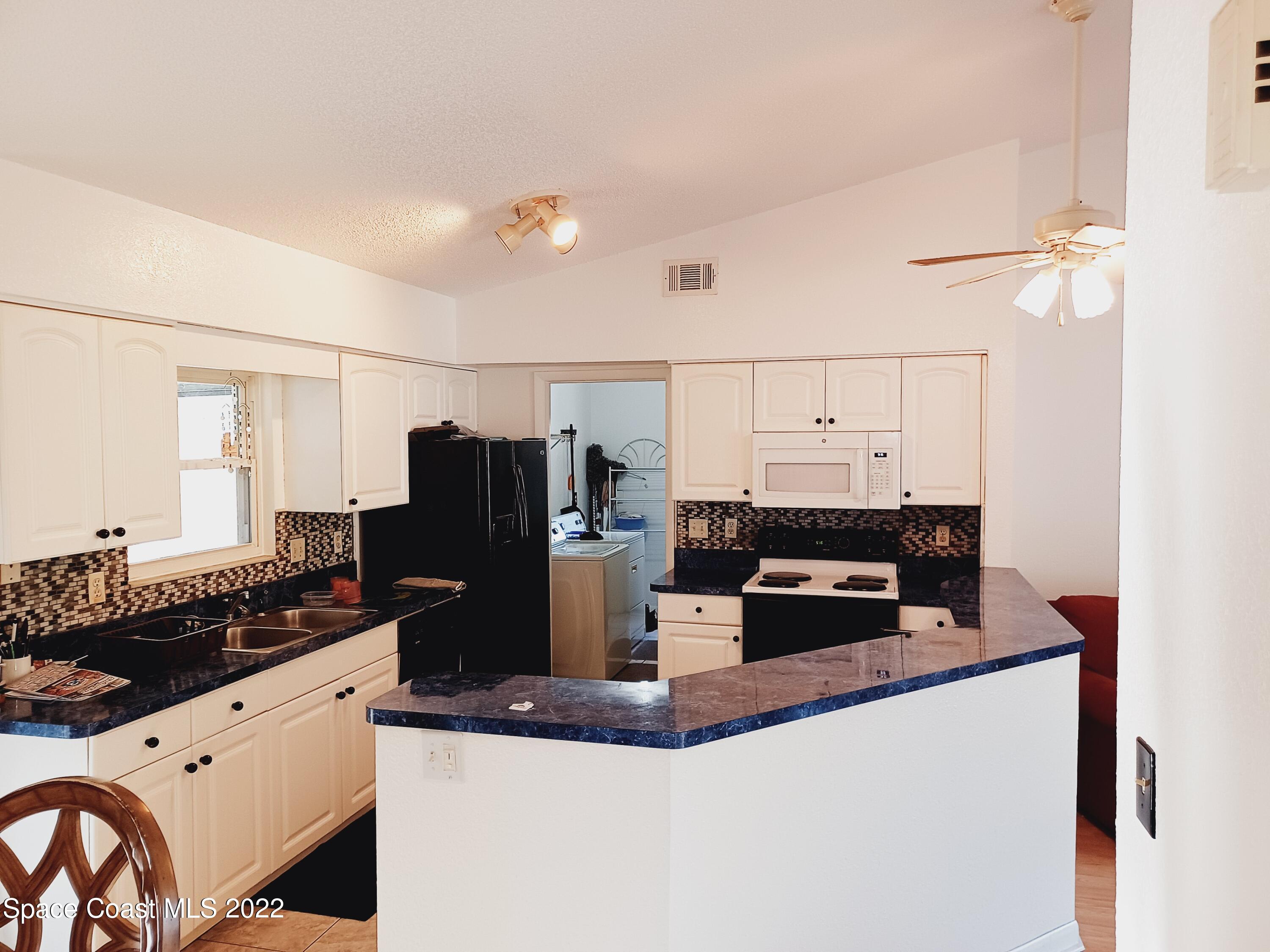 5480 Flint Road Cocoa, FL 32927 - Photo 4 of 20 a kitchen with granite countertop a refrigerator and a stove