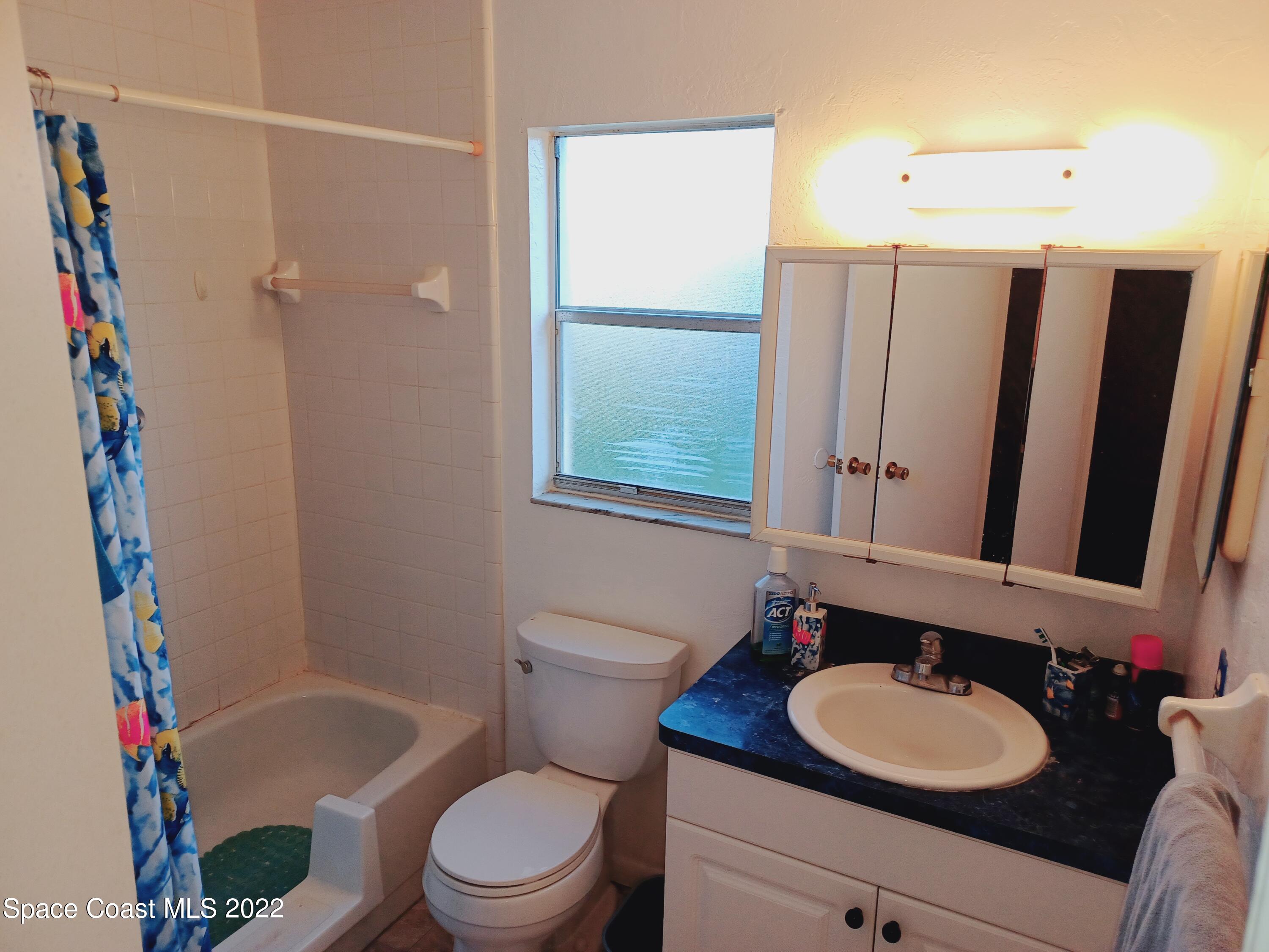 5480 Flint Road Cocoa, FL 32927 - Photo 7 of 20 a bathroom with a sink vanity mirror and toilet