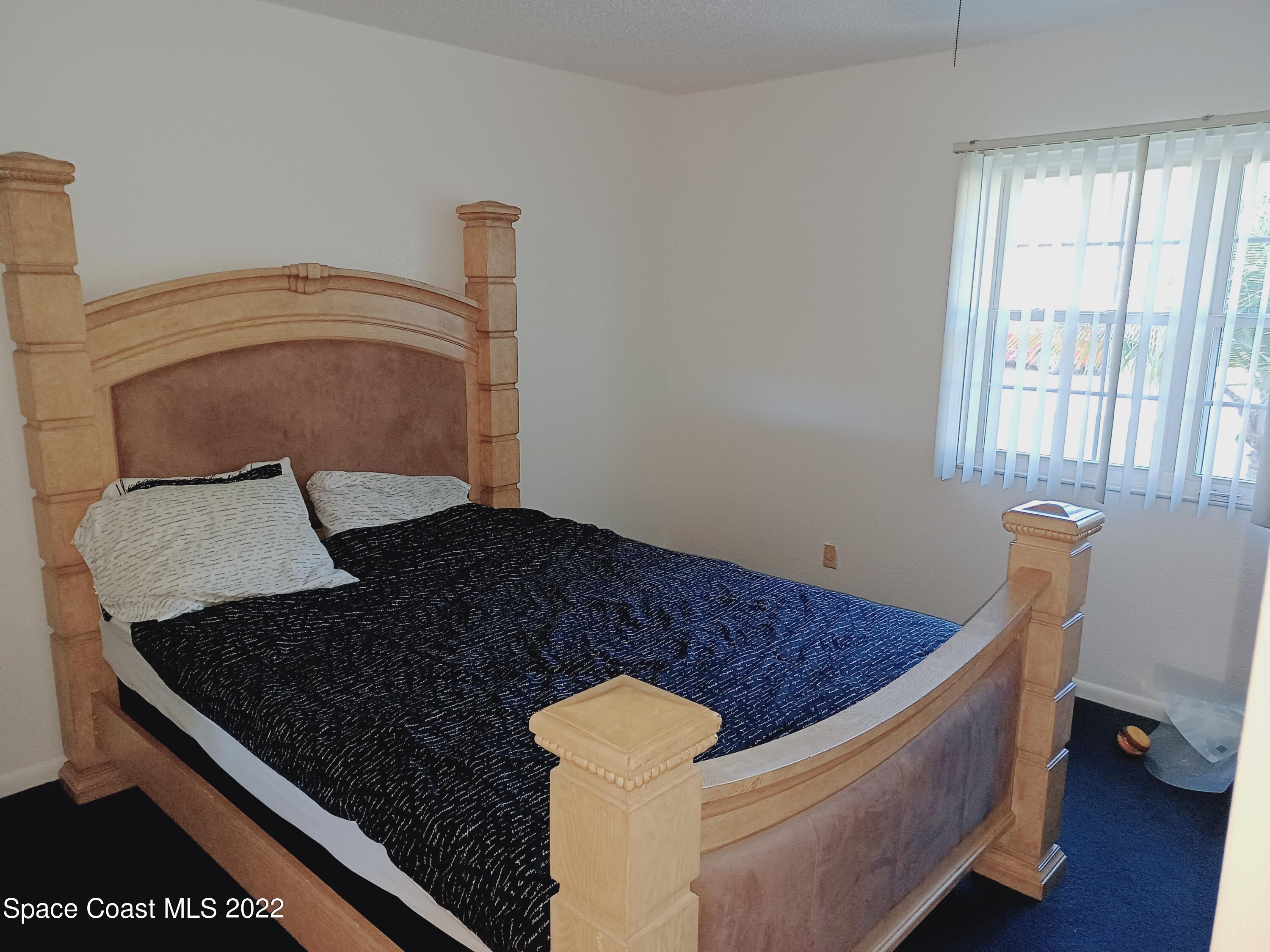 5480 Flint Road Cocoa, FL 32927 - Photo 8 of 20 a bed sitting in a bedroom next to a window