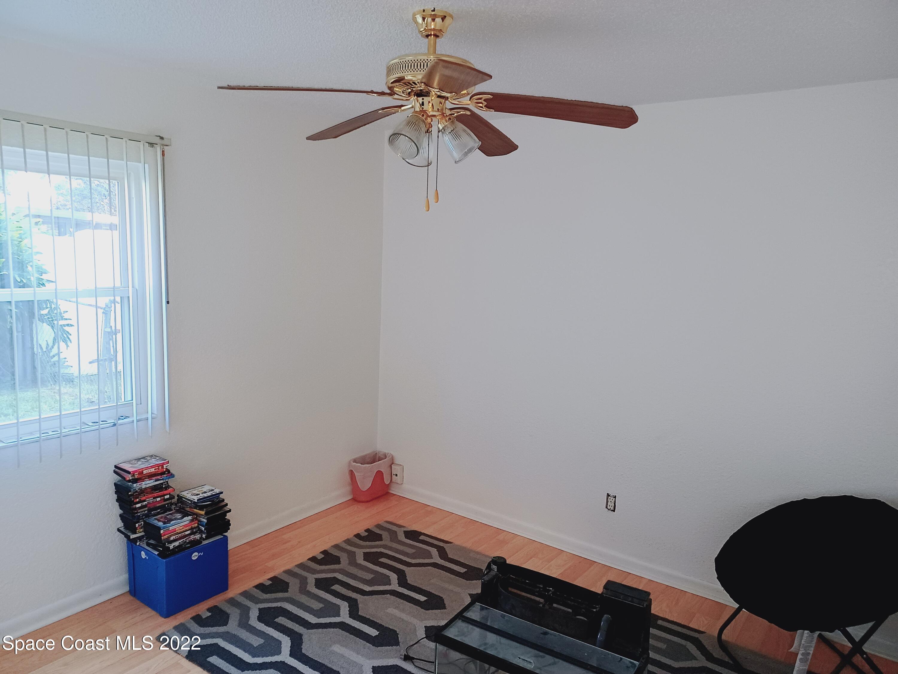 5480 Flint Road Cocoa, FL 32927 - Photo 9 of 20 a bedroom with a bed and a chandelier fan