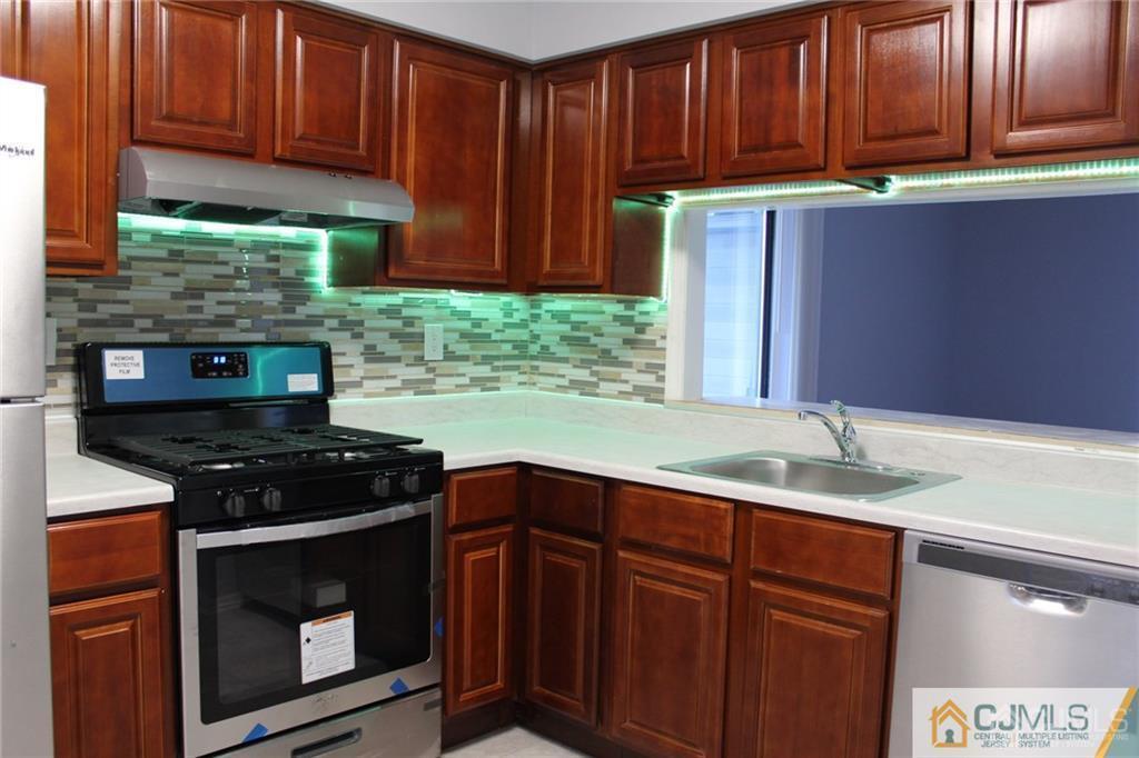a kitchen with granite countertop wood cabinets and stainless steel appliances