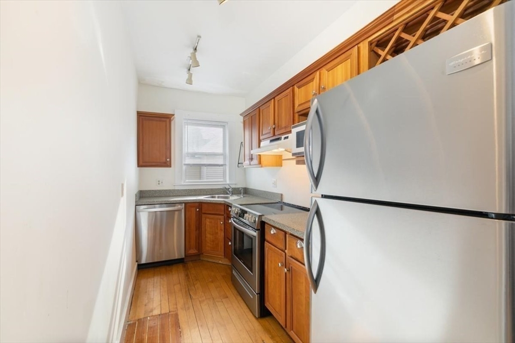 20-22 Florence Street Andover, MA 01810 - Photo 27 of 42 a kitchen with stainless steel appliances granite countertop a refrigerator a stove a sink and a microwave