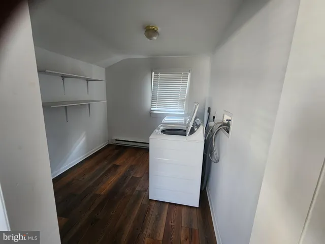 a view of storage and utility room with wooden floor
