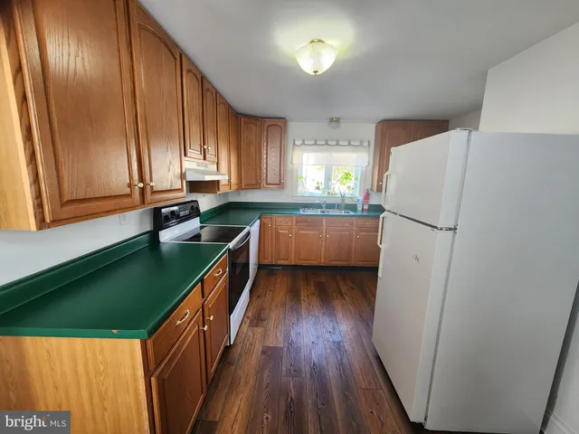 a kitchen with granite countertop stainless steel appliances a refrigerator and a sink