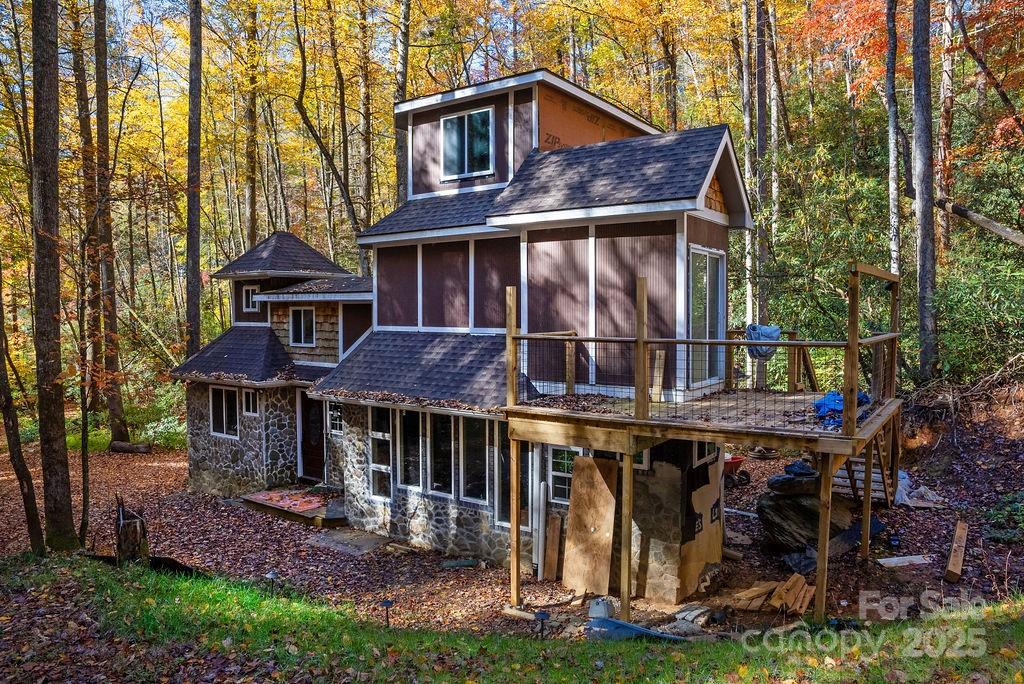 3761 Frozen Creek Road, Unit 31 32 33 Brevard, NC 28712 - Photo 5 of 25 a view of a brick house with large windows and a yard with plants and large trees