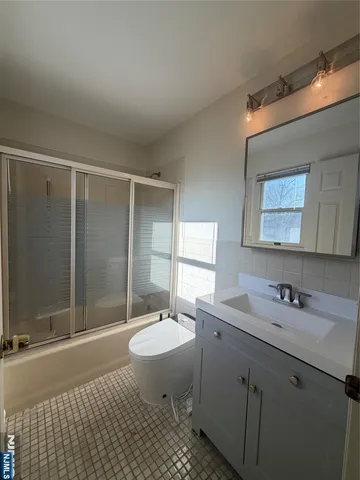 a bathroom with a sink toilet a mirror and shower