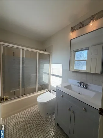 a bathroom with a sink toilet a mirror and shower