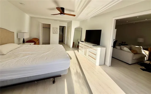 a bedroom with a bed and a flat tv screen on wall