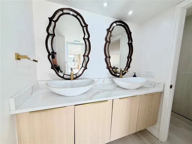a front view of a bathroom with a sink and a mirror