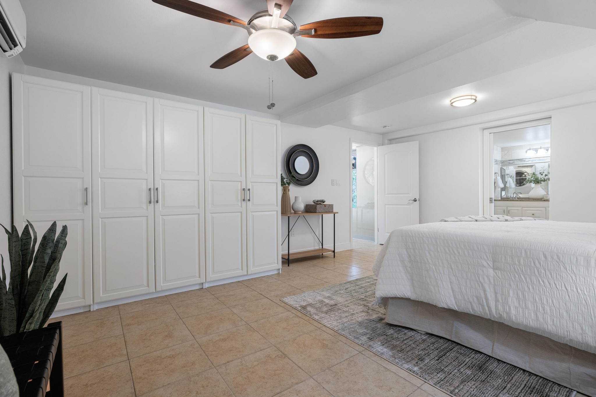 13566 Bullick Hollow Road Austin, TX 78726 - Photo 22 of 32 a spacious bedroom with a bed and a potted plant