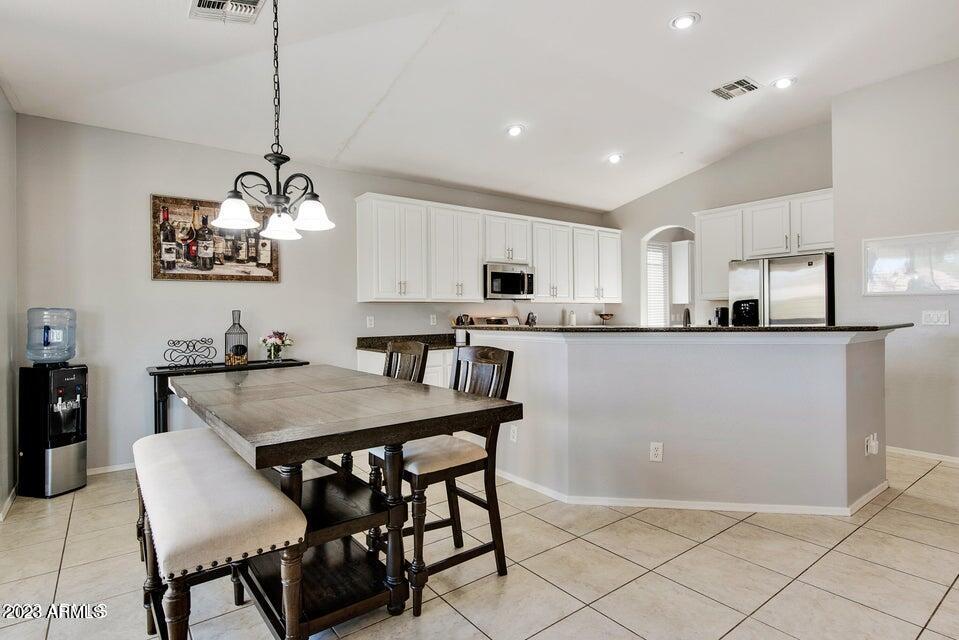2624 West Summerside Road Phoenix, AZ 85041 - Photo 11 of 31 a kitchen with stainless steel appliances granite countertop a kitchen island a stove a table and chairs