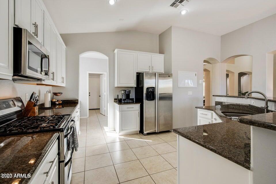2624 West Summerside Road Phoenix, AZ 85041 - Photo 13 of 31 a kitchen with stainless steel appliances granite countertop a sink stove and refrigerator