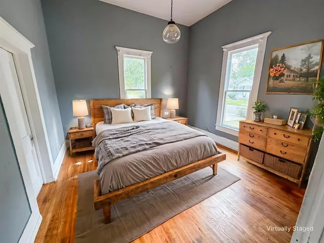 a bedroom with a bed and wooden floor