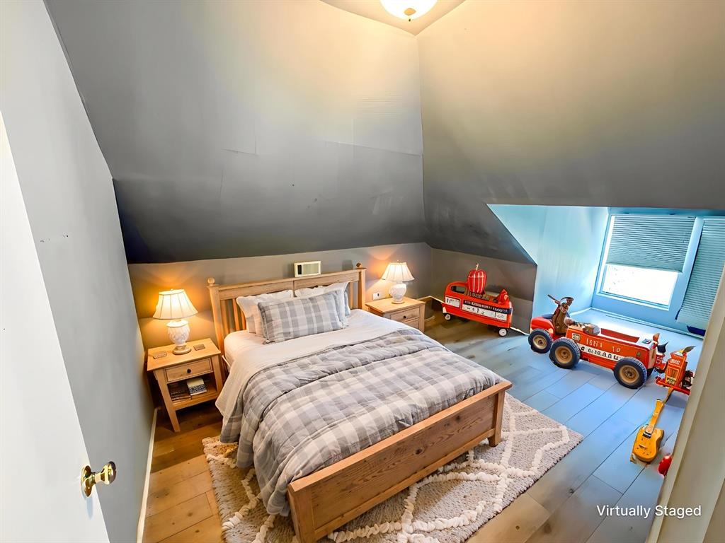 1210 Monroe Street Commerce, TX 75428 - Photo 16 of 20 a bedroom with a bed and wooden floor