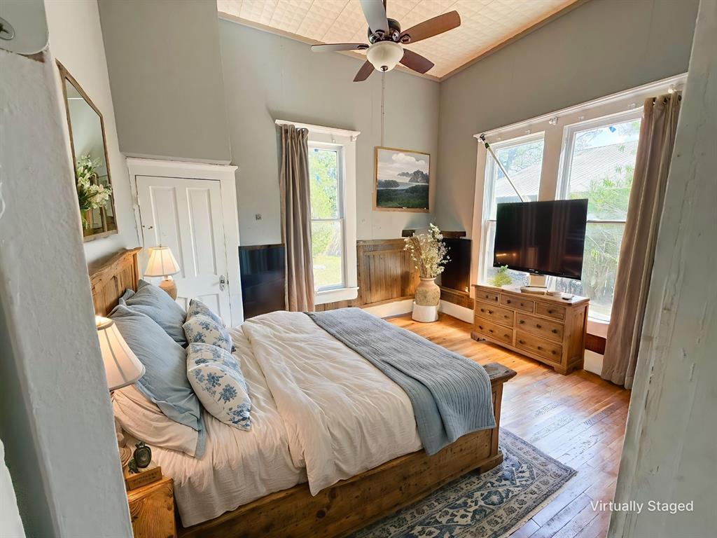 1210 Monroe Street Commerce, TX 75428 - Photo 8 of 20 a bedroom with a bed and a flat screen tv
