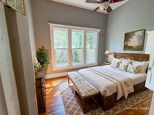 a bedroom with a bed and a large window