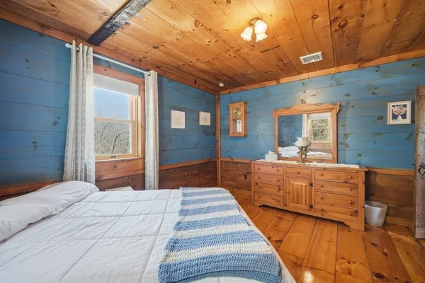 a bedroom with bed and wooden floor