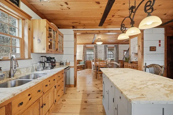 a large kitchen with kitchen island a large counter space a sink appliances and cabinets