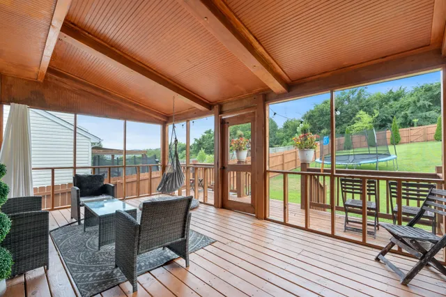 a balcony with wooden floor and outdoor seating