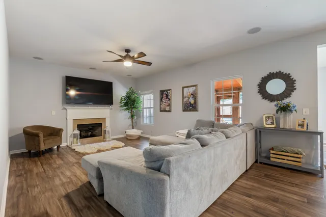a living room with furniture a fireplace and a flat screen tv