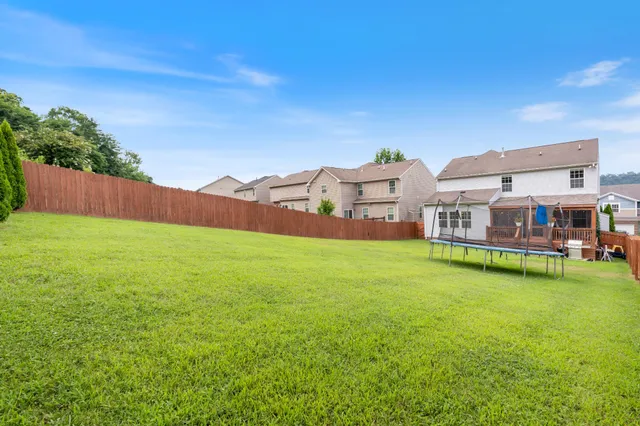 a view of a house with a big yard and large trees