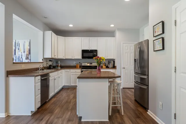 a kitchen with granite countertop a refrigerator stove and microwave