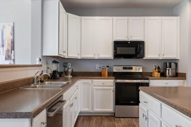 a kitchen with stainless steel appliances granite countertop a sink a stove a microwave and cabinets