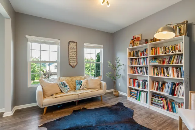 a living room with furniture and a book shelf
