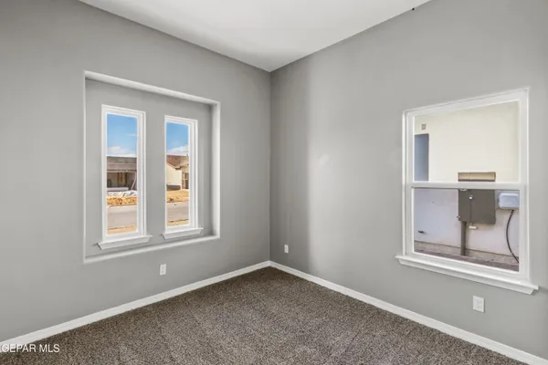 an empty room with windows and cabinet