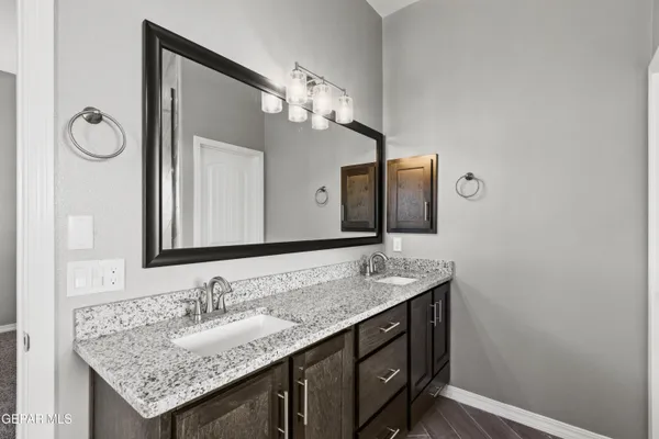 a bathroom with a granite countertop sink and a mirror