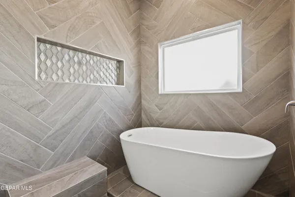 a white tub sitting next to a white window