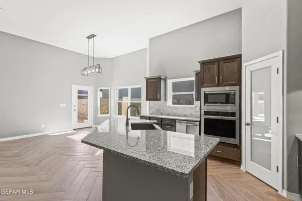a kitchen with stainless steel appliances granite countertop a sink refrigerator and cabinets
