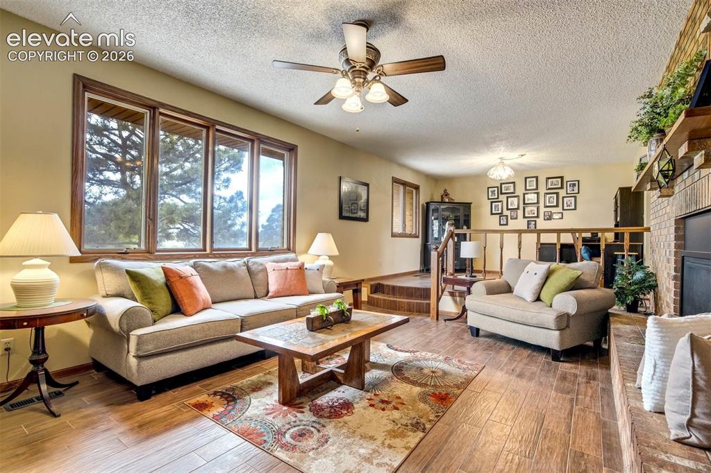 7585 Ponca Road Colorado Springs, CO 80908 - Photo 2 of 49 Gorgeous Living Room Mountain views, wood plank flooring, gas fireplace