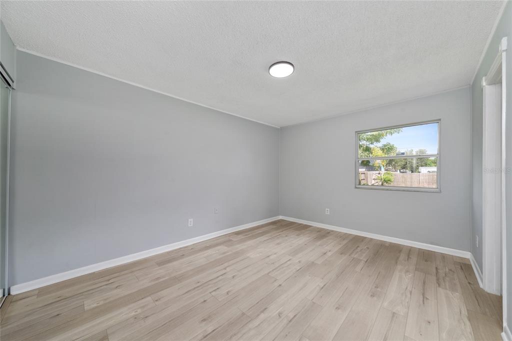 1034 Falcon Street Deltona, FL 32725 - Photo 13 of 36 an empty room with wooden floor and window