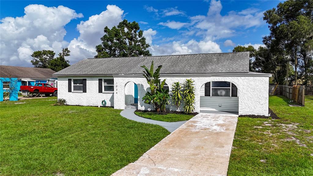 1034 Falcon Street Deltona, FL 32725 - Photo 2 of 36 a front view of a house with a garden