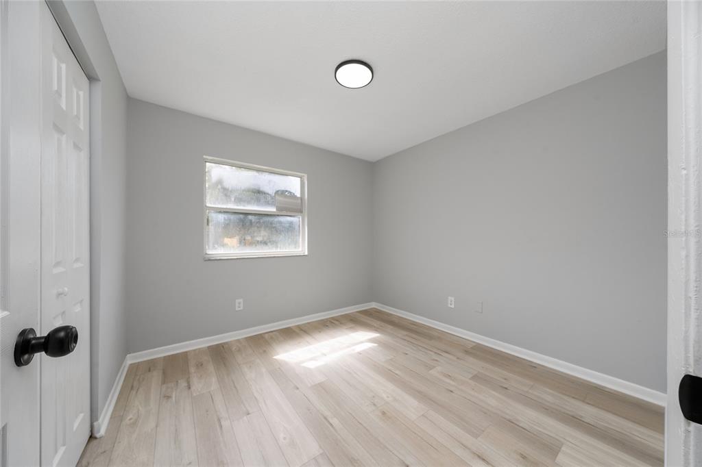 1034 Falcon Street Deltona, FL 32725 - Photo 23 of 36 an empty room with a window and wooden floor