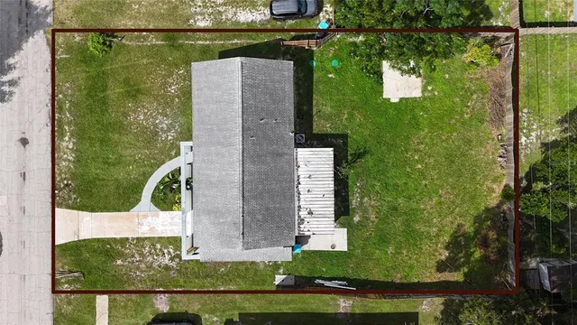 an aerial view of a house with a yard basket ball court and outdoor seating