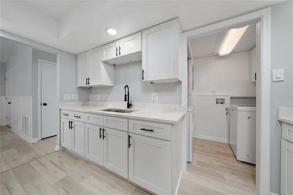 a kitchen with sink cabinets and wooden floor