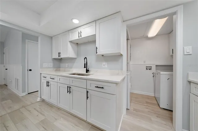a kitchen with sink cabinets and wooden floor