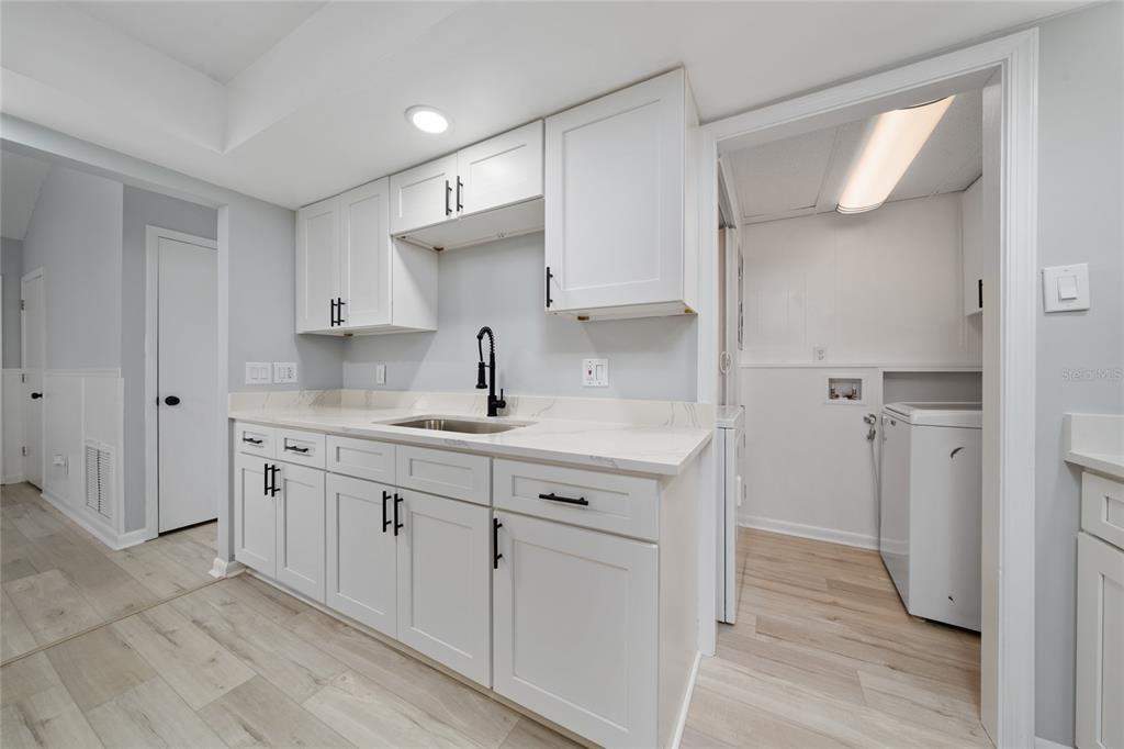 1034 Falcon Street Deltona, FL 32725 - Photo 6 of 36 a kitchen with sink cabinets and wooden floor