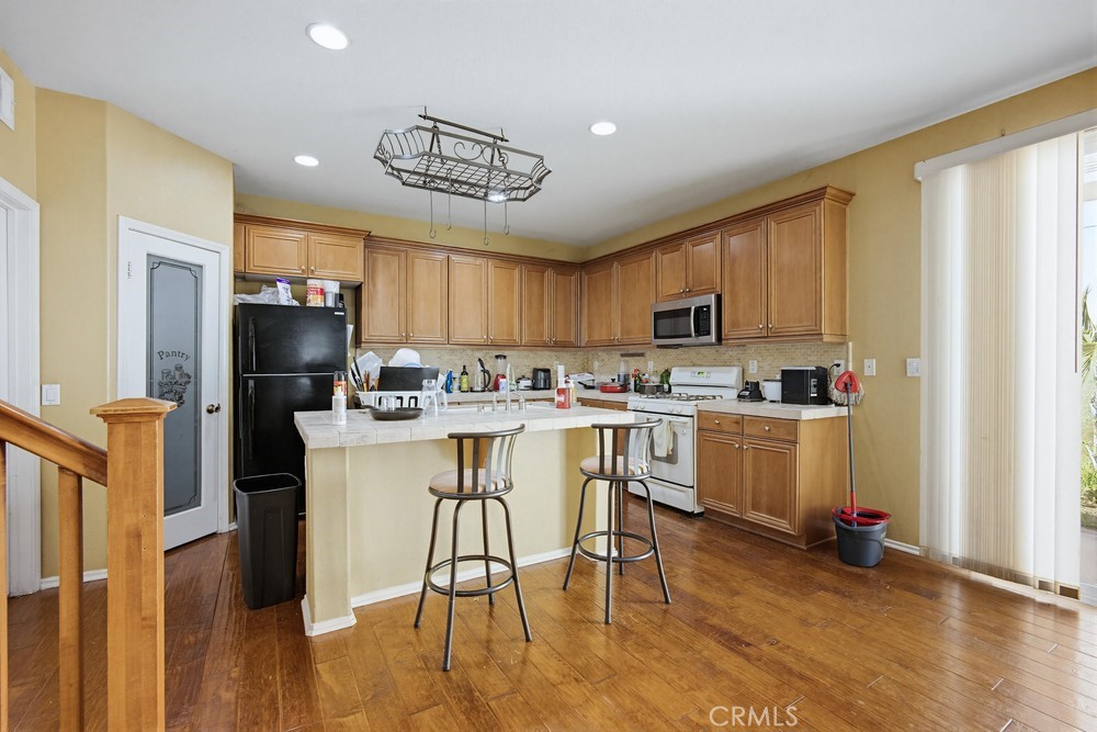 1747 Palermo Drive Riverside, CA 92507 - Photo 9 of 30 a kitchen with a refrigerator a stove cabinets and a dining table
