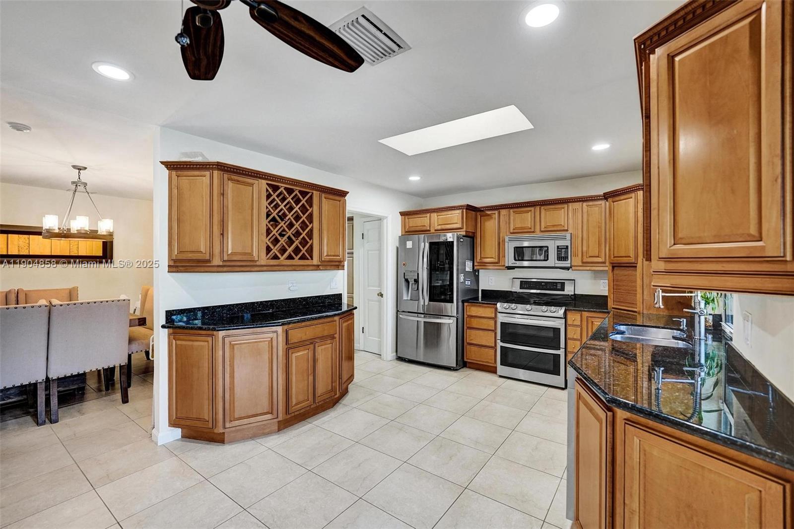 1501 Northwest 99th Avenue Plantation, FL 33322 - Photo 12 of 45 a kitchen with stainless steel appliances granite countertop a stove top oven a sink dishwasher and a refrigerator